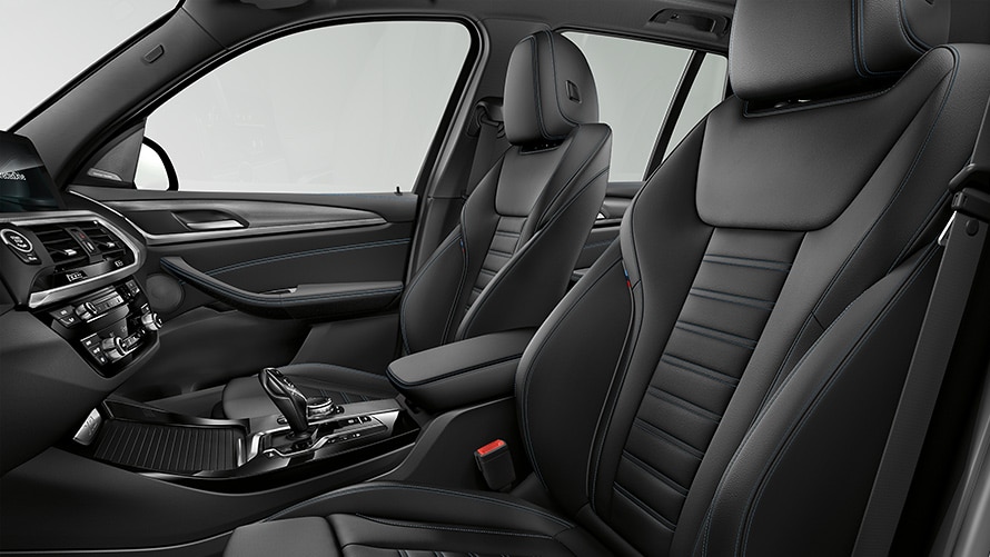 Elegant interior of a BMW car with black leather seats and blue details, modern design, and high-quality finishes.